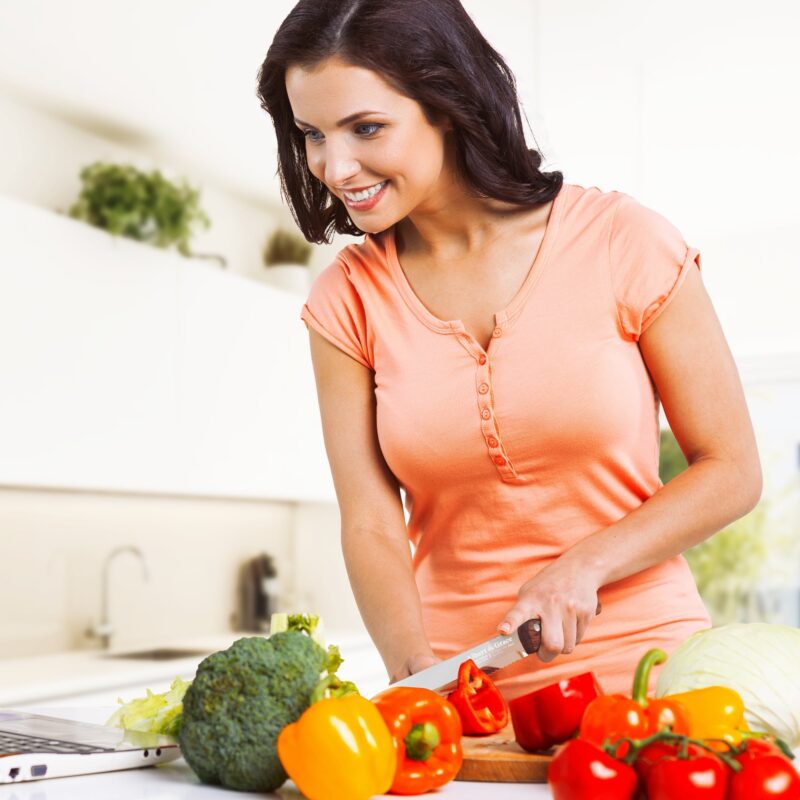 woman cutting vegetables with bread knife